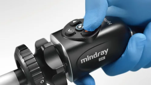 Головка камеры Mindray 4K в руке в синей перчатке, палец нажимает кнопку на корпусе