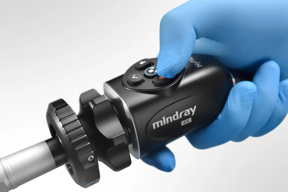 Головка камеры Mindray 4K, присоединённая к жёсткому эндоскопу, в руке в синей перчатке